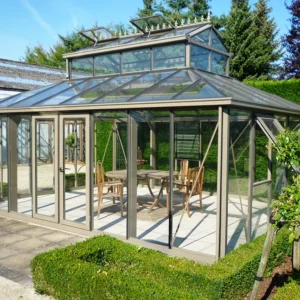 Front of the Janssens Cathedral Glass Greenhouse in Bronze set up in a backyard