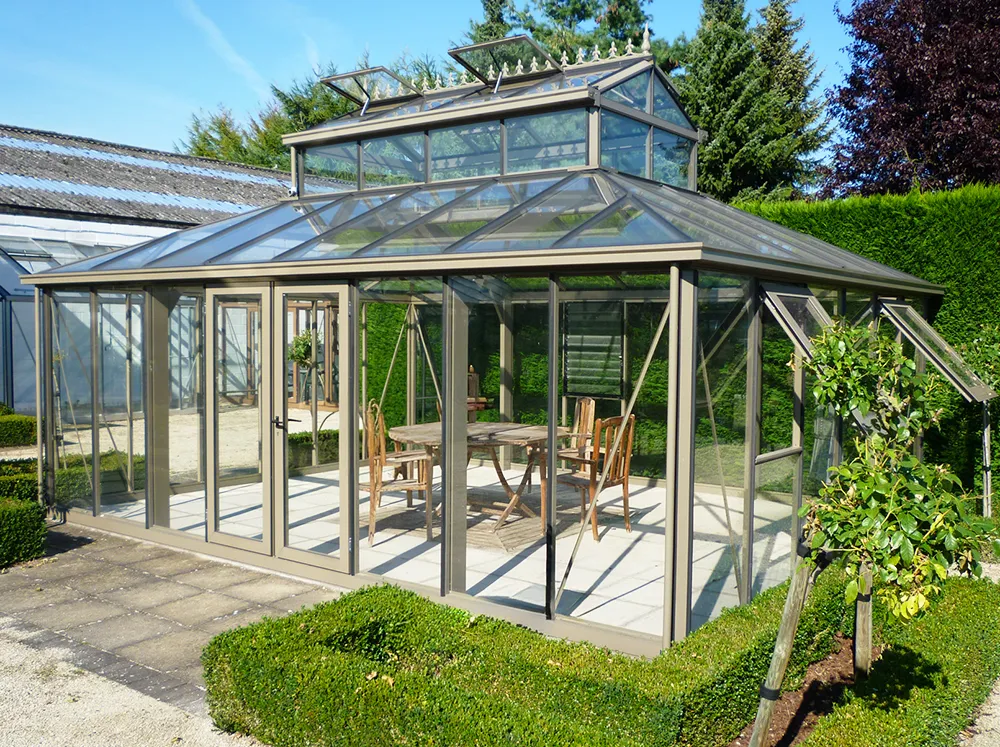 Front of the Janssens Cathedral Glass Greenhouse in Bronze set up in a backyard
