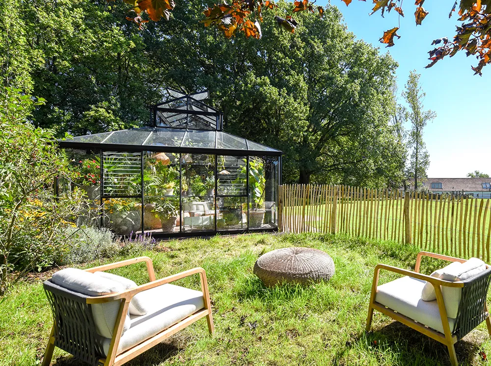 Side view of the Janssens Cathedral Glass Greenhouse in a backyard