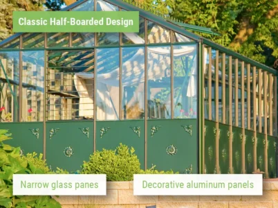 Sun-lit shot of the Janssens Retro Victorian Greenhouse with Green framing showcasing the decorative metal panels and narrow glass