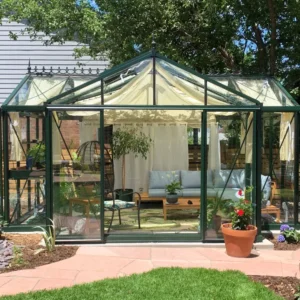 Front of green-framed Janssens Royal Victorian Orangerie with seating inside and shade curtains