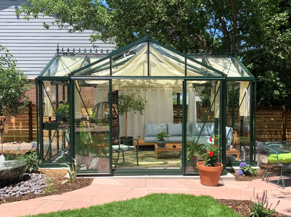 Front of green-framed Janssens Royal Victorian Orangerie with seating inside and shade curtains