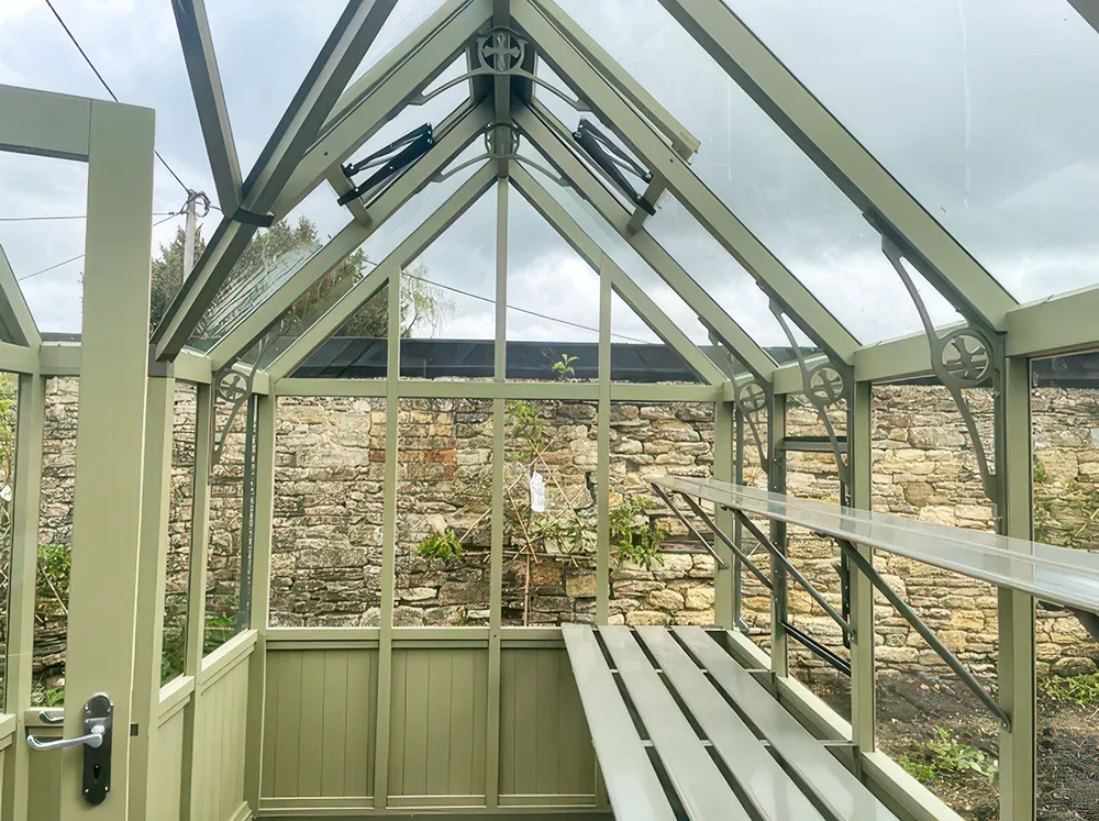 Interior shot of the Alton Durham Orangerie painted in green with shelving on the backwall