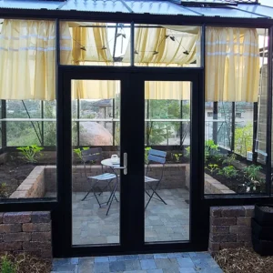 Janssens Greenhouse installed on a stem wall with a Drop Door Kit so that the entry way is on ground level