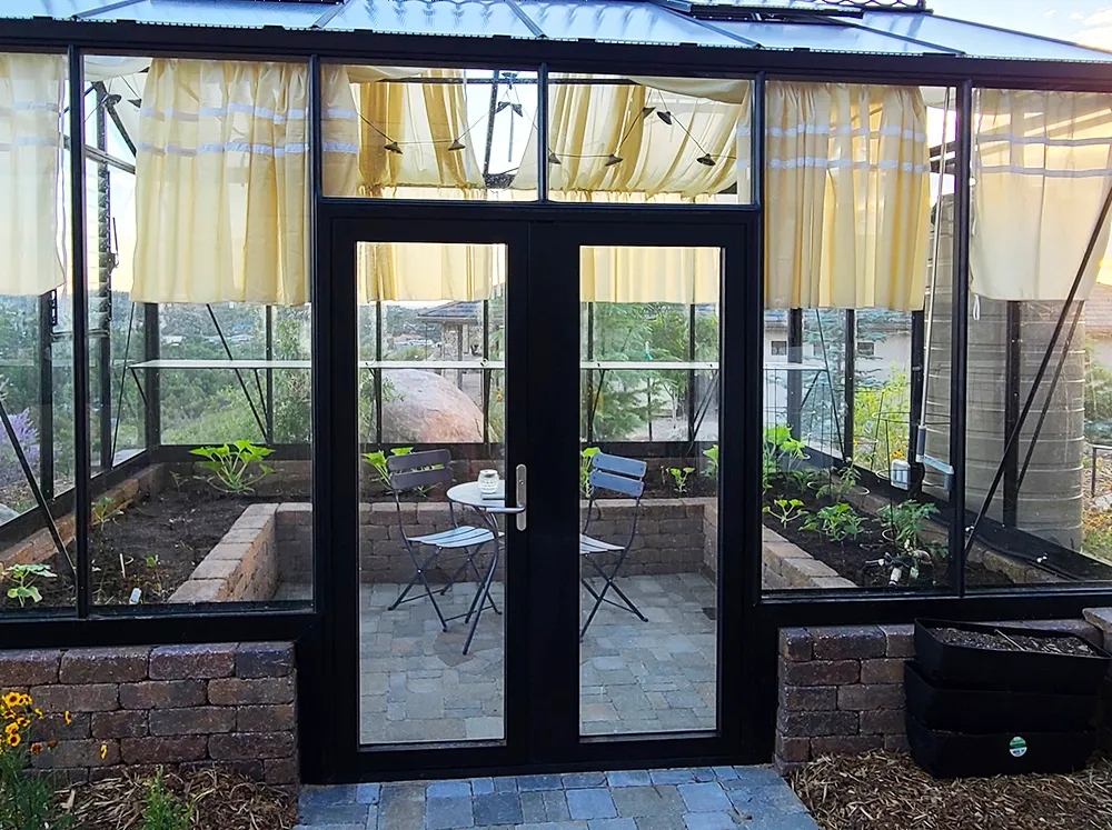Janssens Greenhouse installed on a stem wall with a Drop Door Kit so that the entry way is on ground level