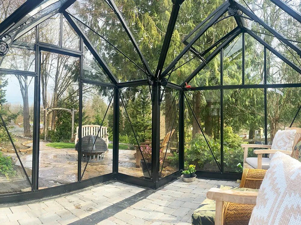 Interior shot of a glass Orangerie greenhouse with the view into the backyard