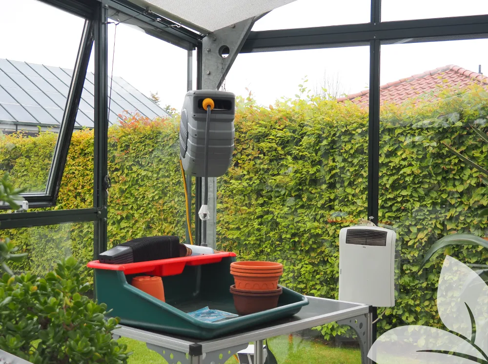 Interior of a glass greenhouse with lots of different greenhouse accessories