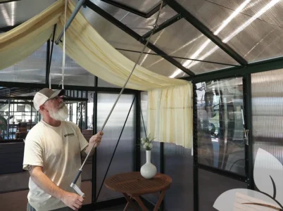 Man using handle to adjust the Janssens Spindle Opener for a roof vent