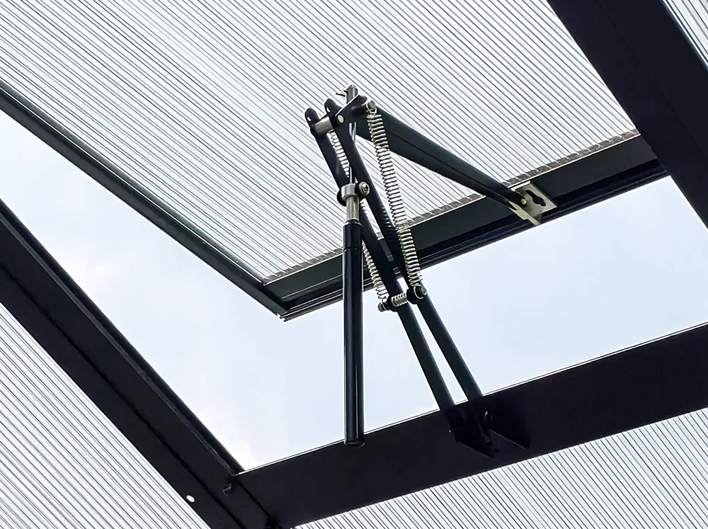 Interior view of a Vego Auto Vent Openers installed on a roof vent - open position