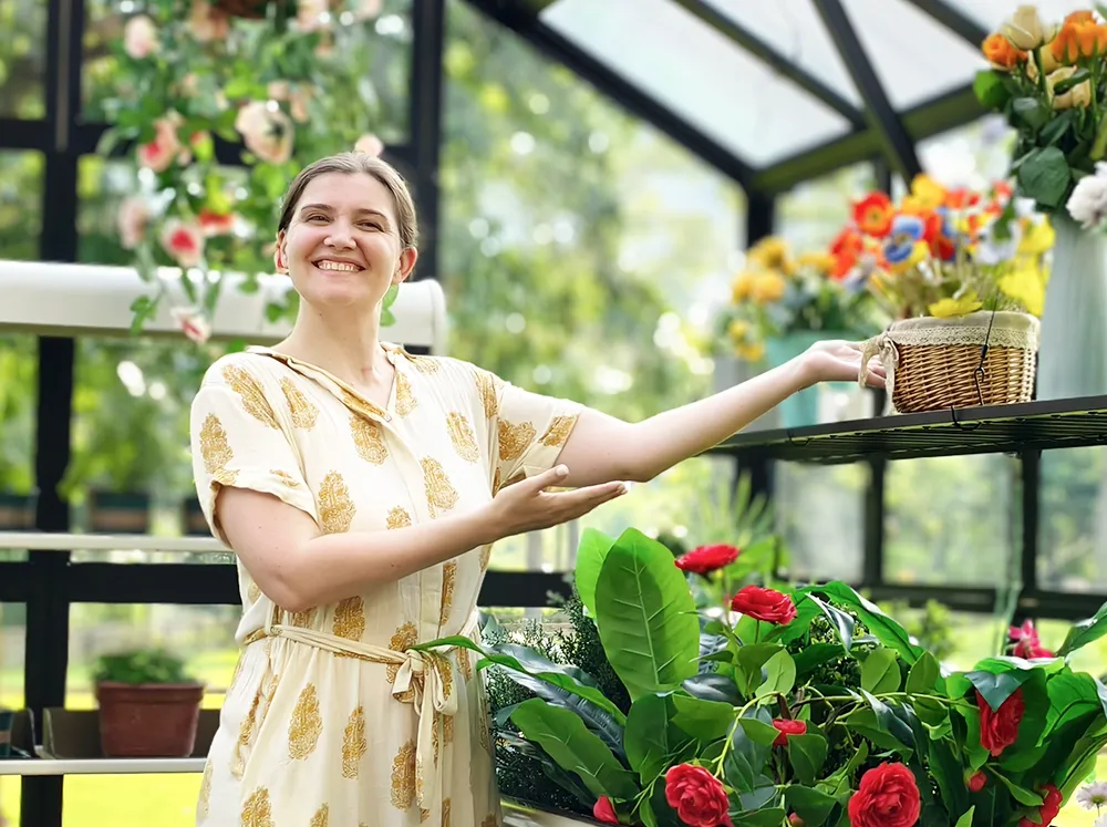 Interior shot of the Vego Victorian Greenhouse with a woman smiling