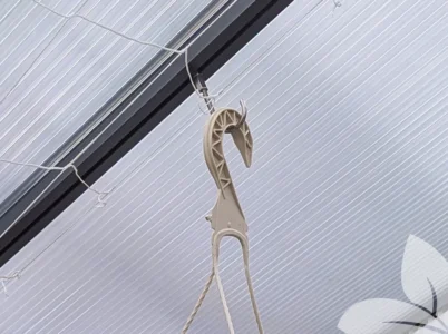 Adjustable J Hook installed in greenhouse with a hanging planter on it