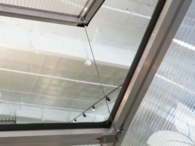 Fully opened greenhouse roof vent with the Wind Restraint Kit taut, stopping it from opening any further