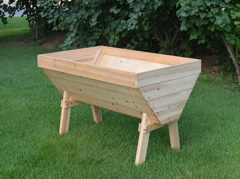 Wooden Eden Deep Root V-Shaped Garden Table on a lawn without soil or plants