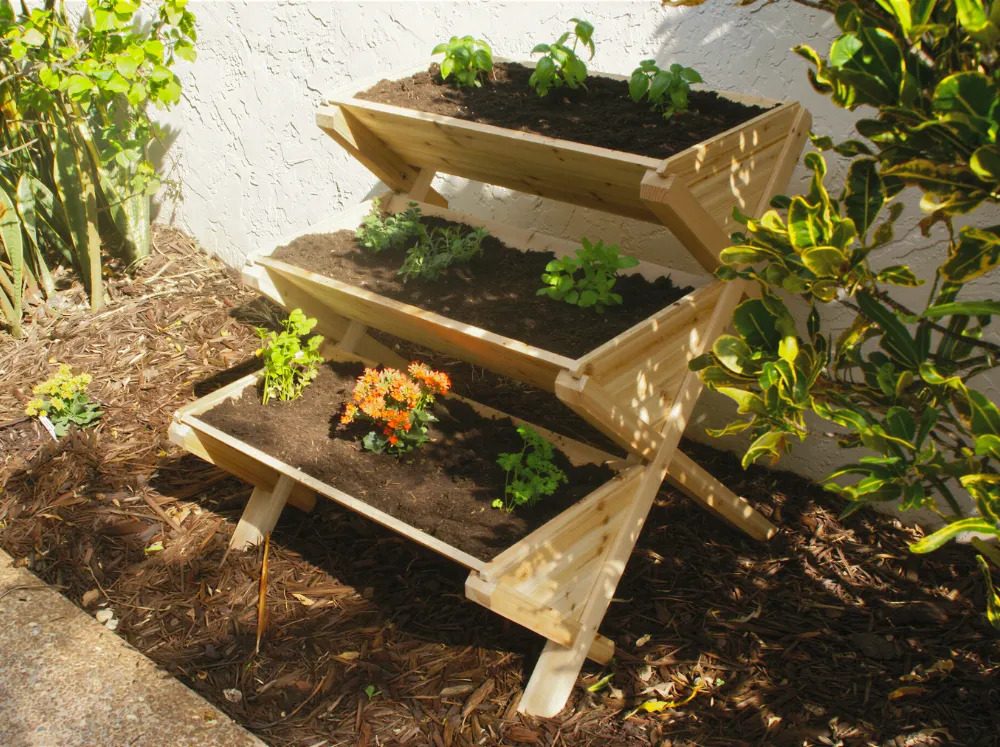 Eden Waterfall Garden Table with plants inside standing along a wall