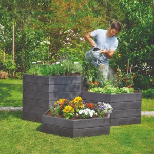 Different modular heights of Graf Hexagonal Raised Bed in backyard with person watering plants