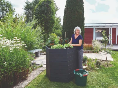 Woman with plants planted in Graf Hexagonal Raised Bed