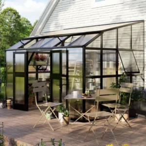 Vego Grand Lean-To Greenhouse installed against a house wall with a bistro table set in front